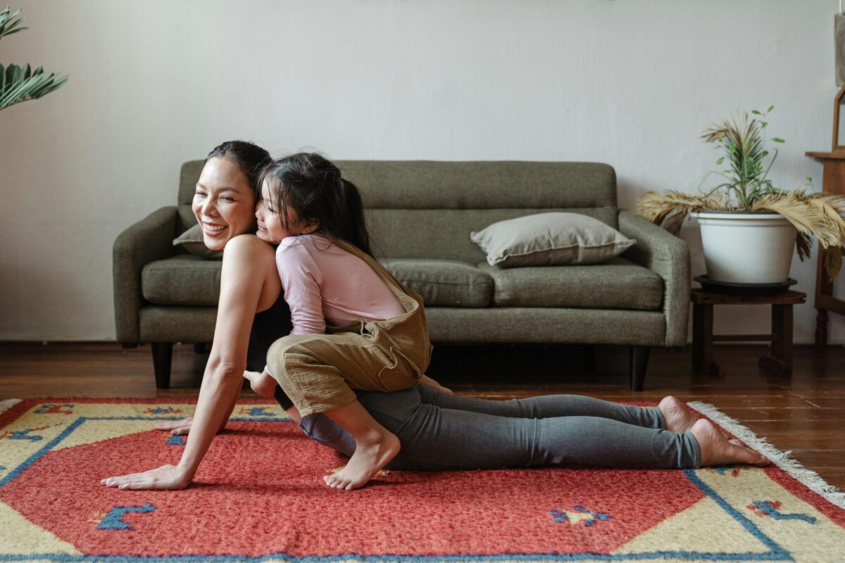 Solo mum and daughter sharing a playful family ritual at home, combining exercise and quality time together.