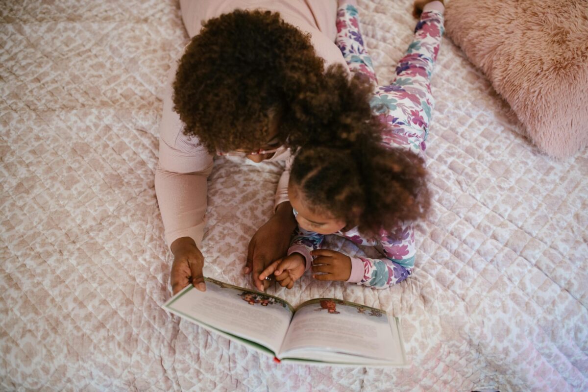 Mother and daughter reading a bedtime story, showing family rituals that strengthen bonds and help children feel safe.